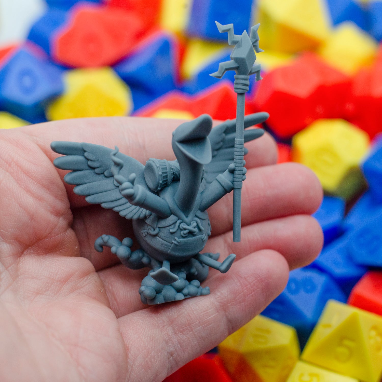 3D printed custom TTRPG mini in grey resin of a goose wearing a hoodie, holding a staff and suspended on a cloud of bubbles.