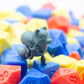 Gray 3d printed miniature figurine of a fox among colorful plastic dice