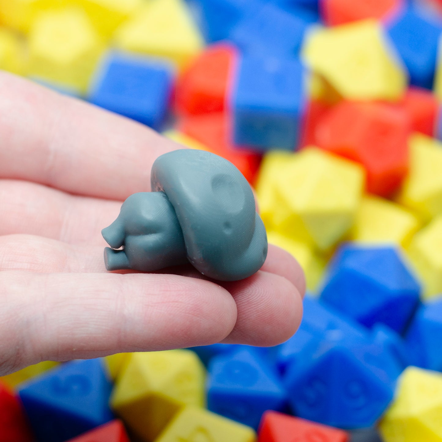 A 3d printed mushroom guy laying on its side, photographed from the back so you can see its wee booty cheeks.