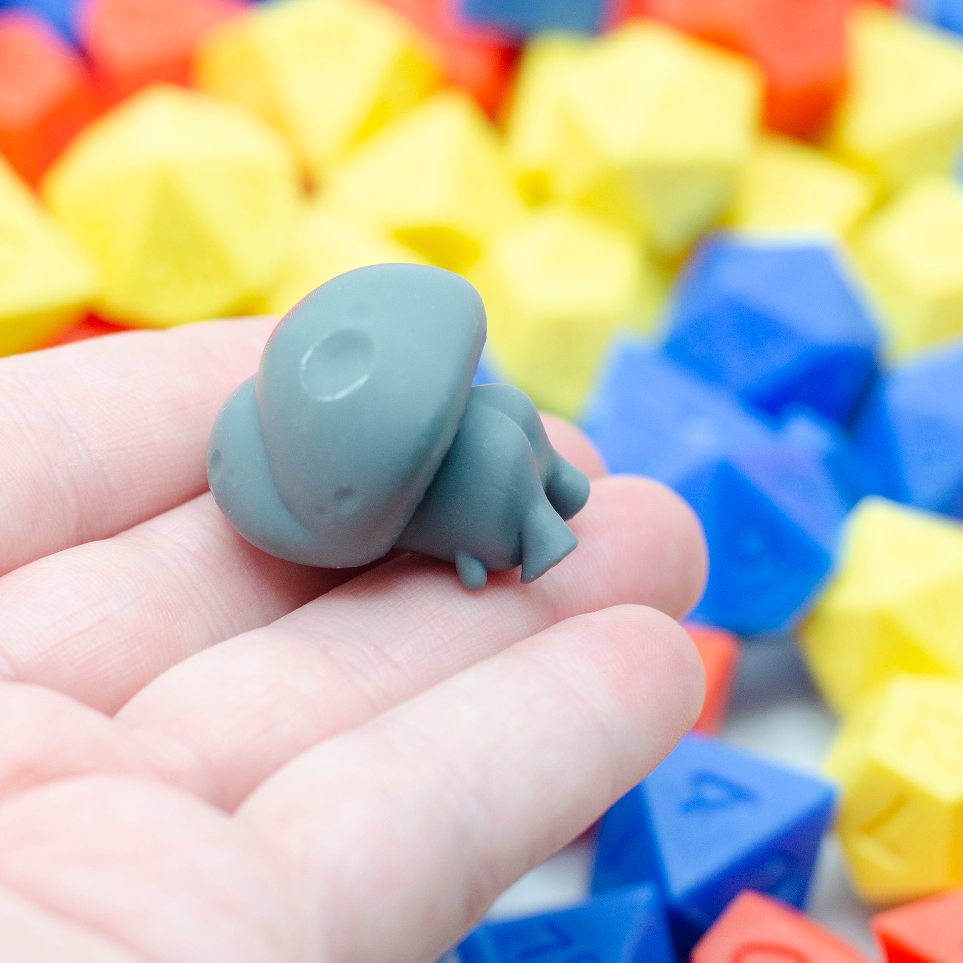 A 3d printed mushroom guy laying face down, little booty cheeks in the air.