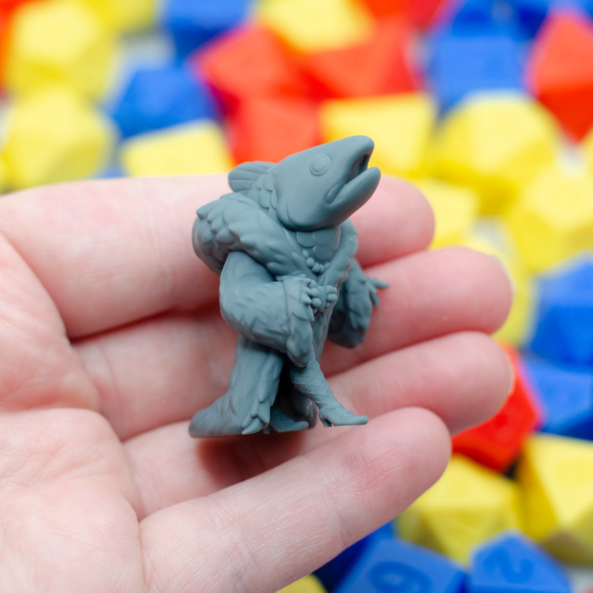 A side-view of the 3d printed reverse mermaid miniature, held in hand for scale.