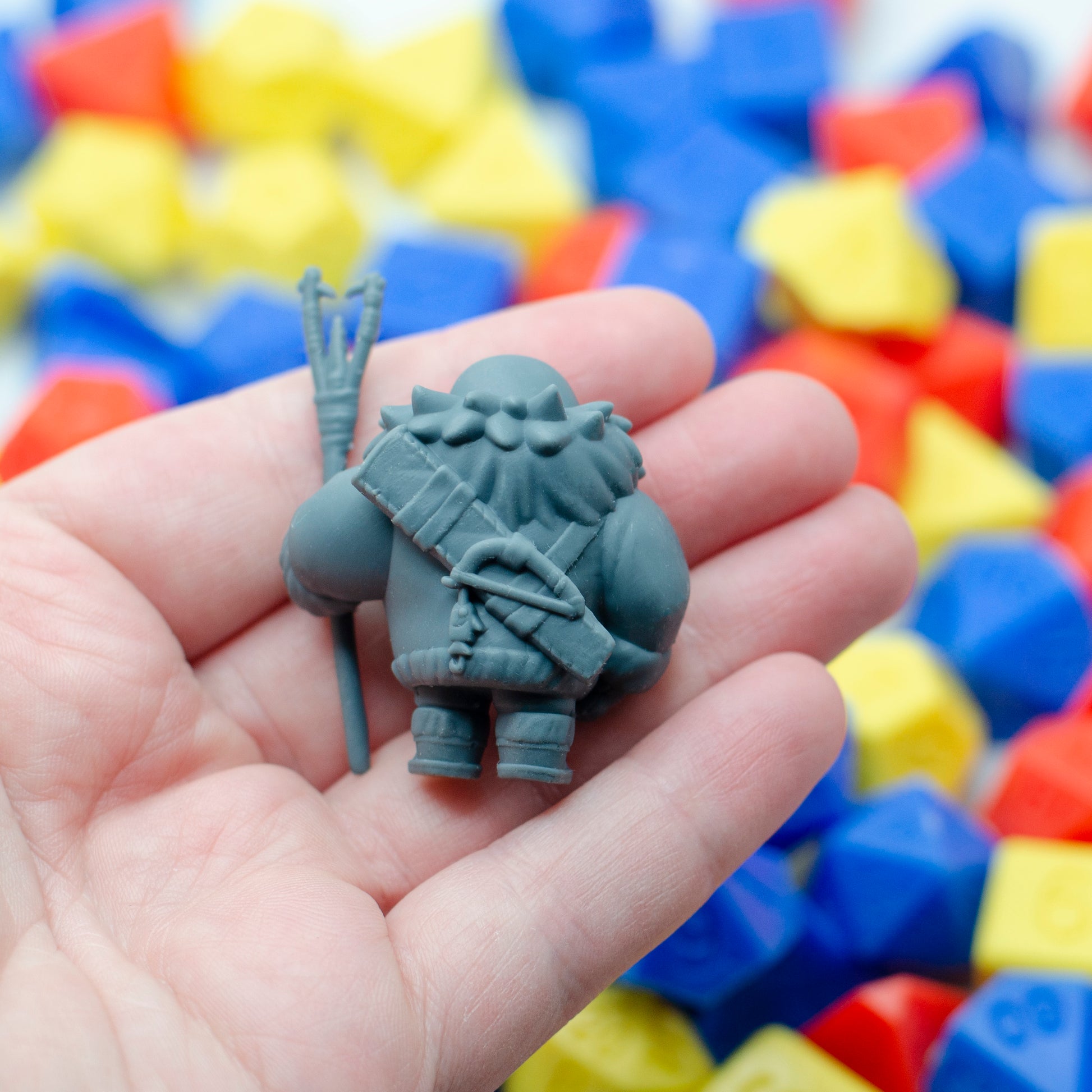 The back of the 3d printed parent seal fisher miniature, showing a holster for the spear and a smaller fishing stick with fish shaped lure.